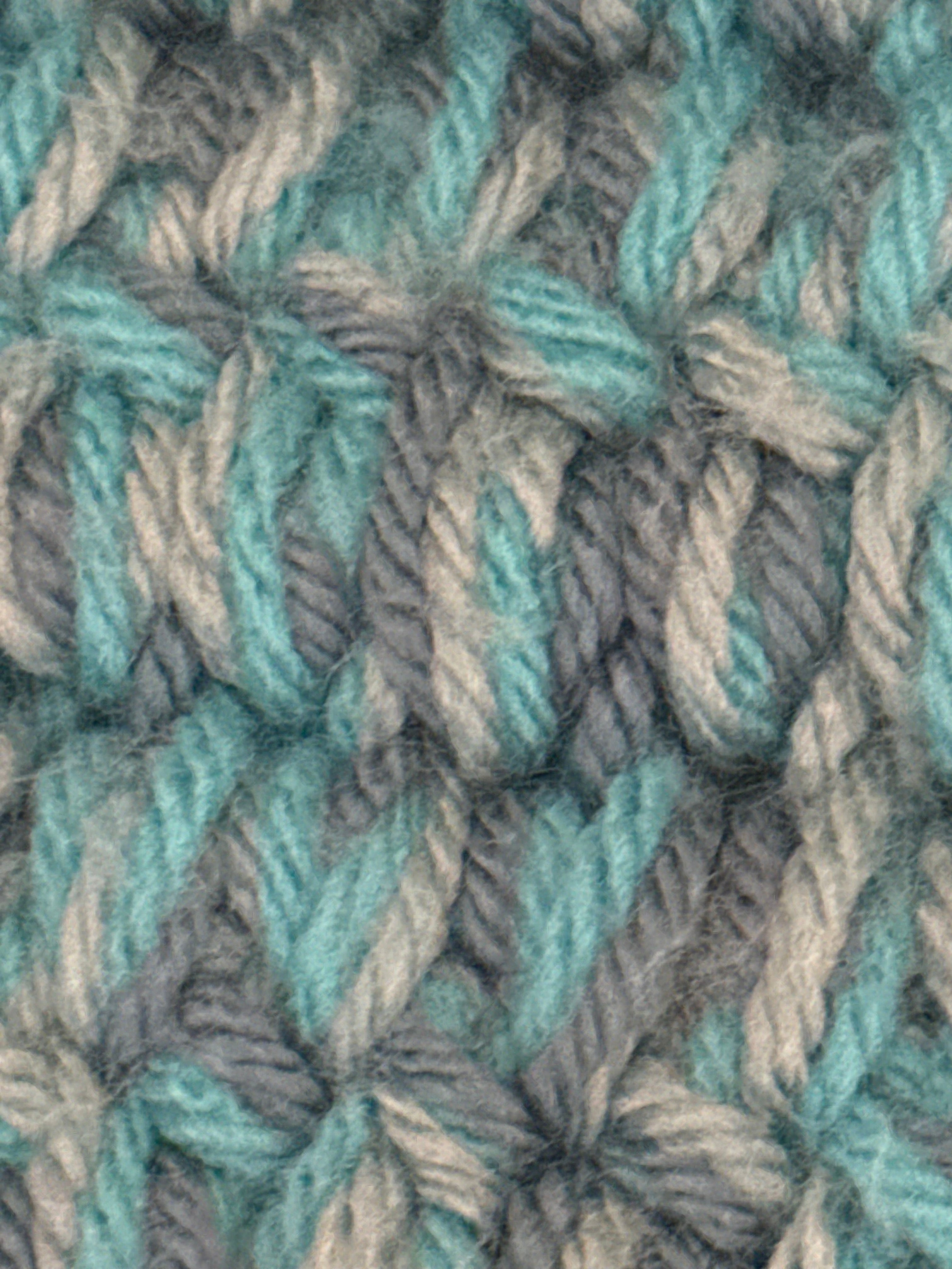 Close-up of handmade turquoise crochet blanket showing detailed stitch texture